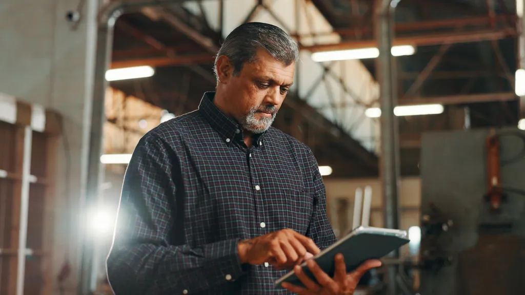 Workshop owner checking a job on a tablet